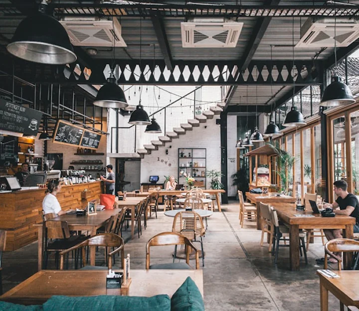 Cafe interior with long tables and a pastry counter